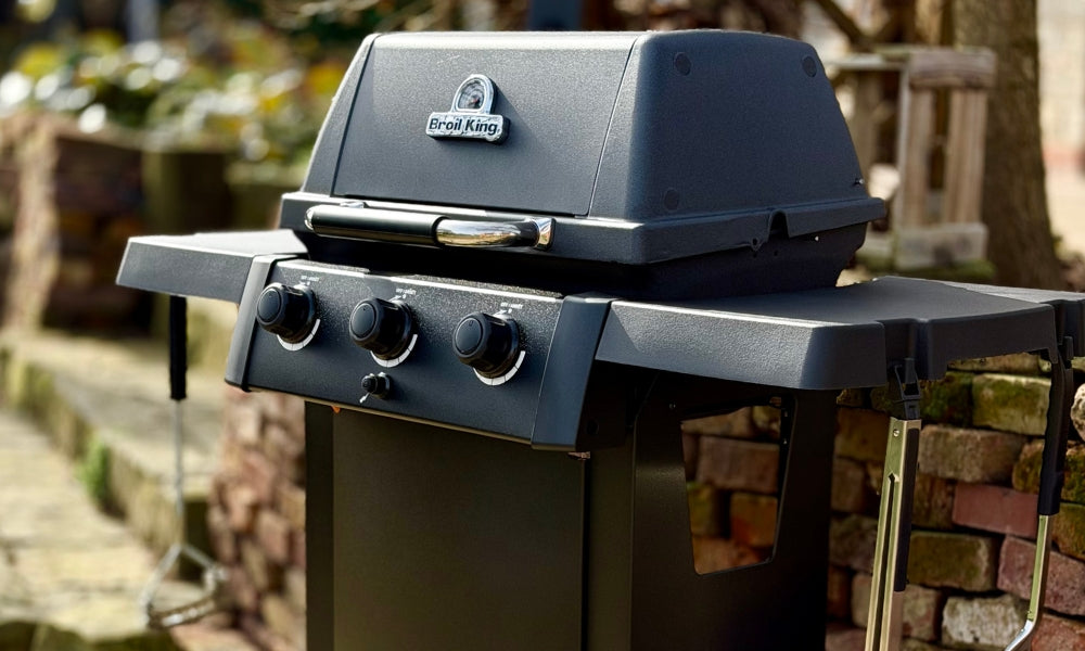 Black barbecue grill with brand logo on a blurred outdoor background