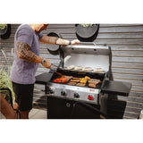 Person grilling vegetables on a barbecue grill outdoors.